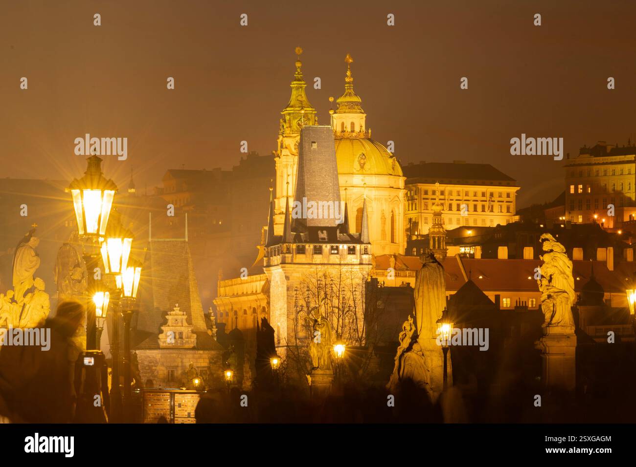 Passeggiata notturna attraverso il centro storico di Praga con torri illuminate e cupole di monumenti medievali Foto Stock