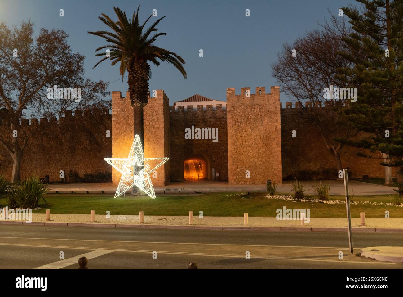 L'arco d'ingresso del Castelo de Lagos, il Castello di Lagos, di notte a Lagos, Algarve in Portogallo a Natale con stella di Natale illuminata Foto Stock