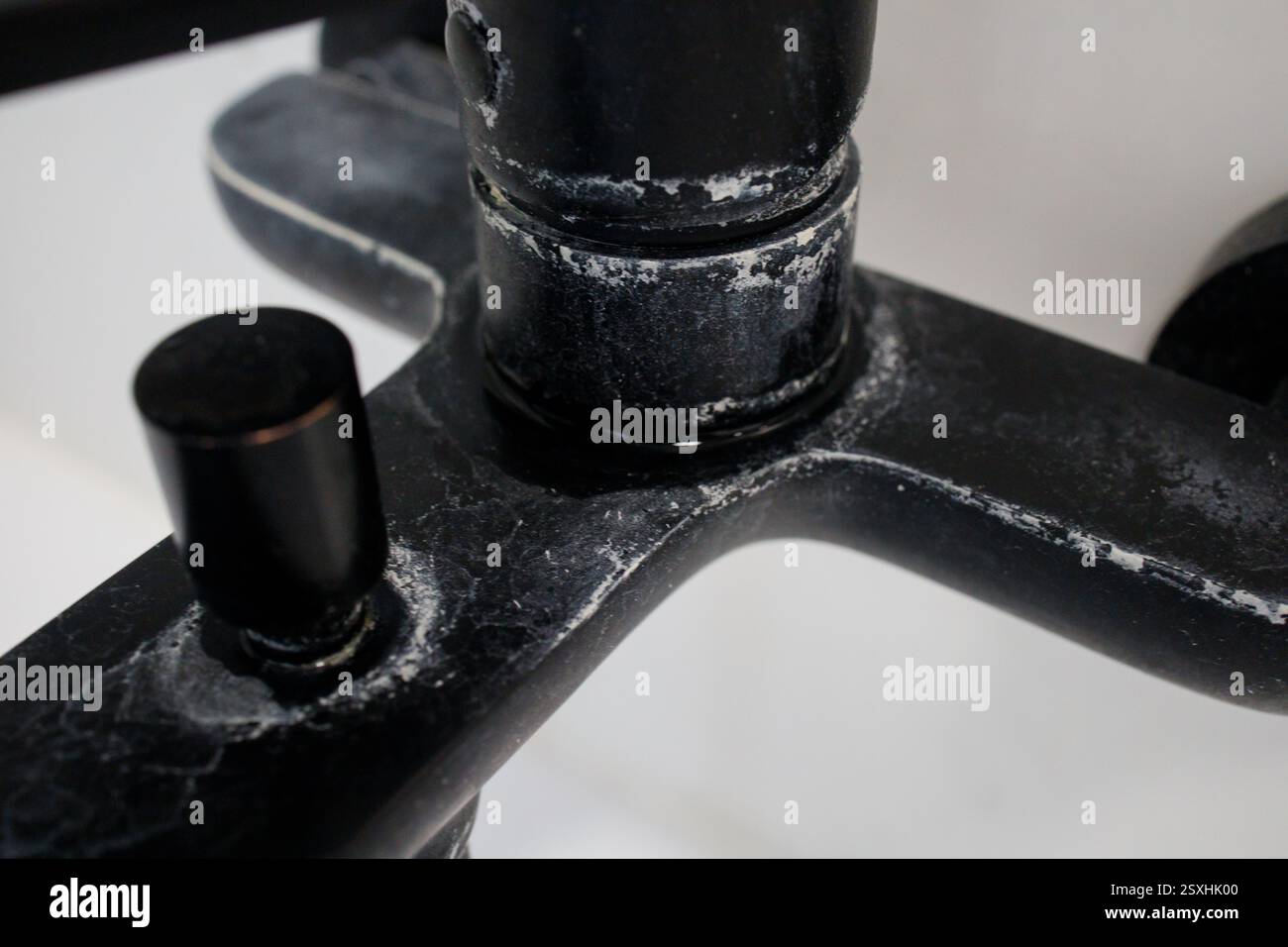 Calcare intenso su un rubinetto nero del bagno da vicino Foto Stock