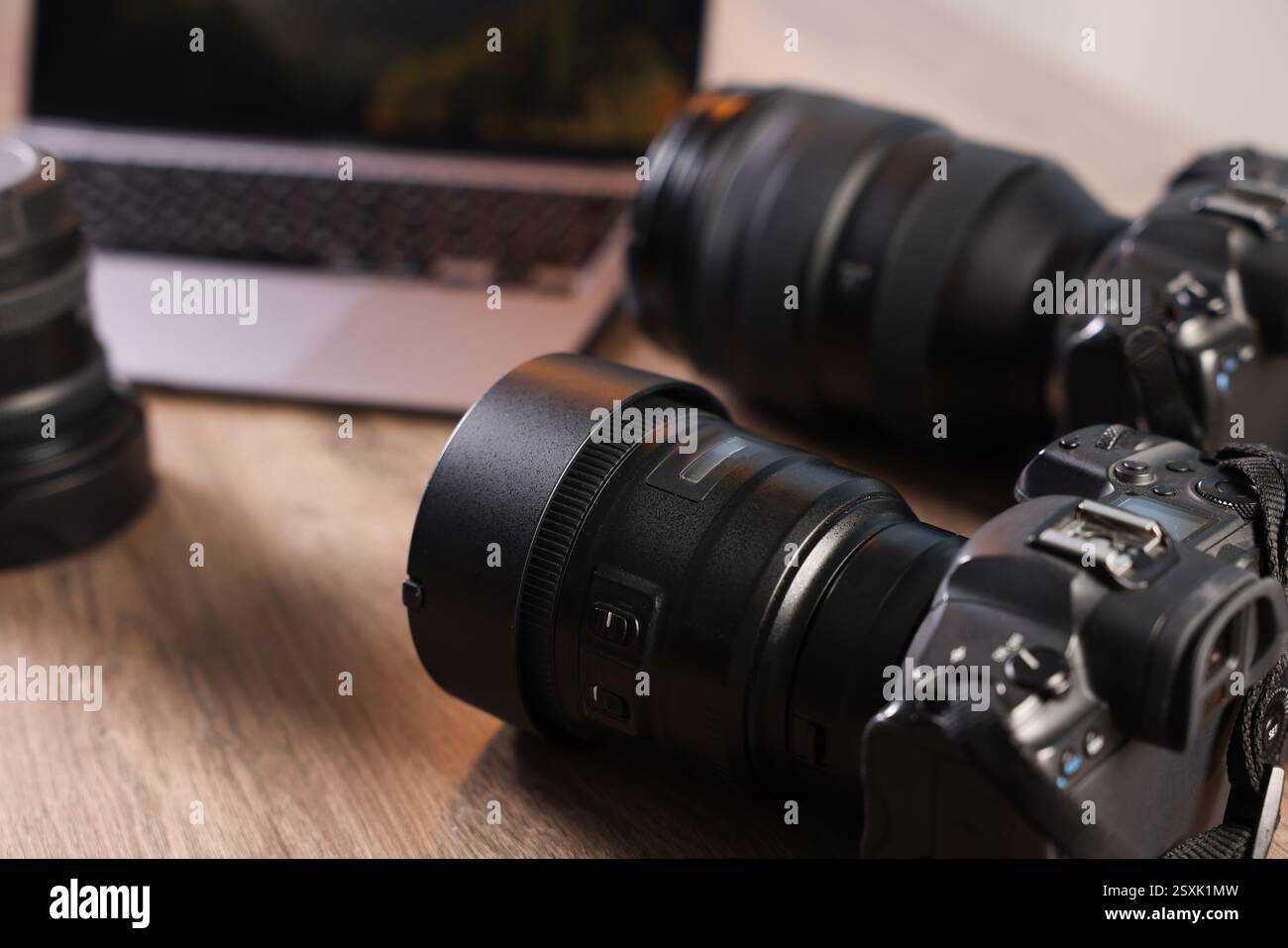 Fotocamere professionali e computer portatile su una scrivania in legno, primo piano Foto Stock