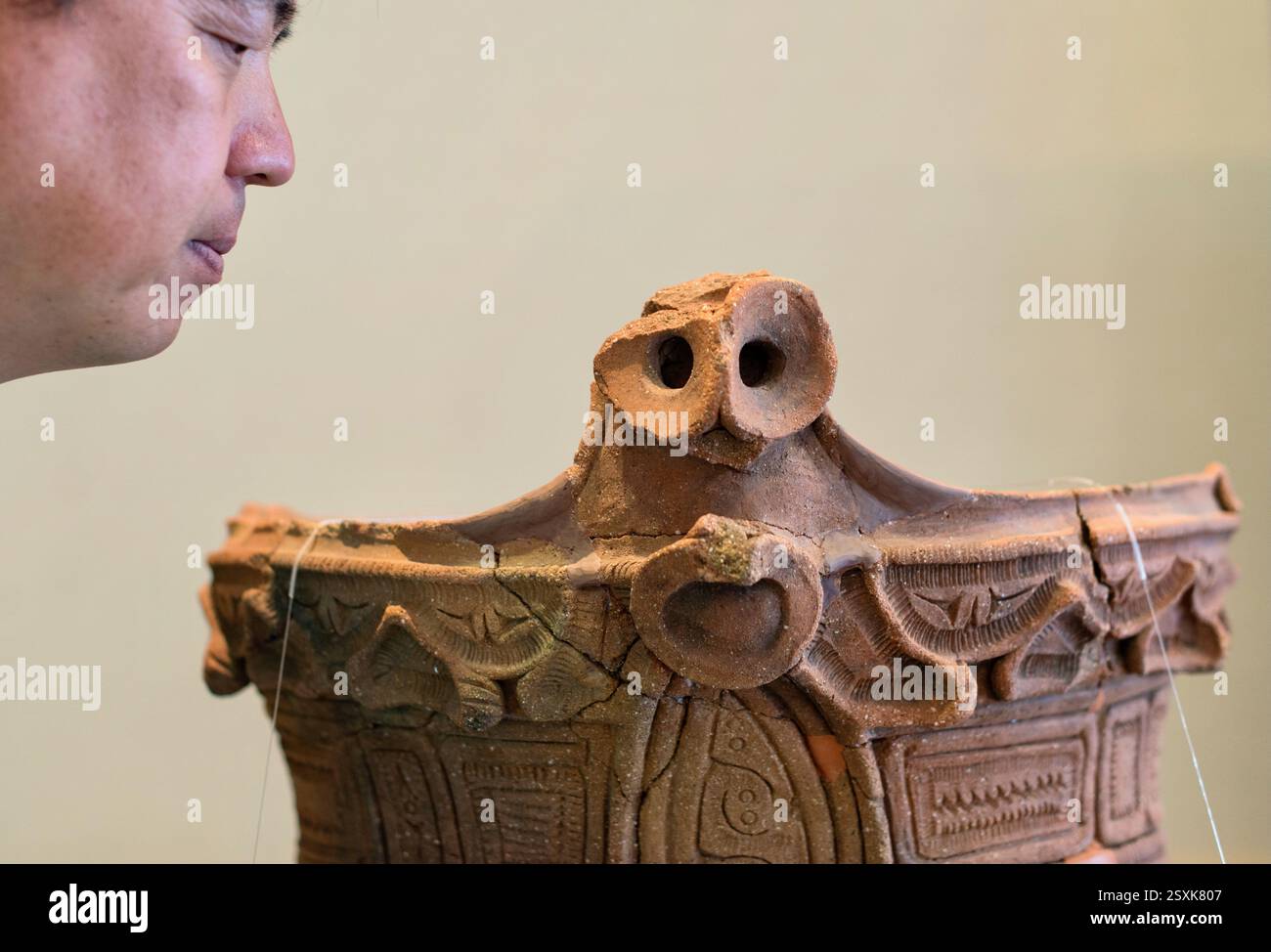 Yoshiyuki Muramatsu, capo della divisione patrimonio del dipartimento di istruzione della città di Hokuto, guarda un oggetto risalente all'era Jomon (14000-300 a.C.) Foto Stock