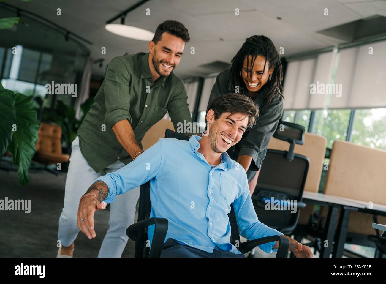 Un gruppo di giovani lavoratori d'ufficio multirazziali e diversificati viene colto in un momento di gioia spontanea. Foto Stock