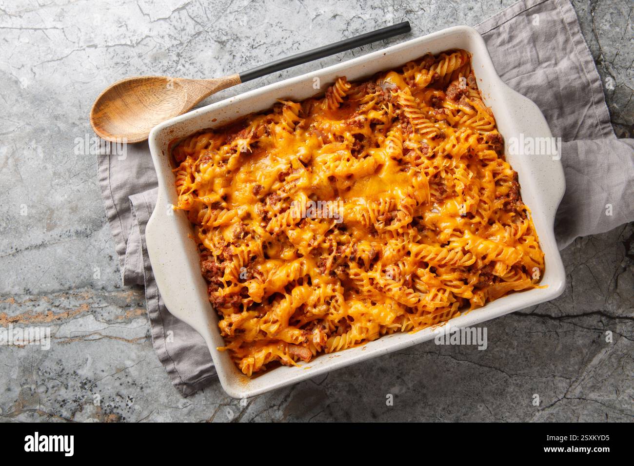 Casseruola piccante di joe sciocco con manzo, pasta, verdure e salsa e un sacco di formaggio in primo piano nel piatto da forno sul tavolo. Vista dall'alto orizzontale da ab Foto Stock