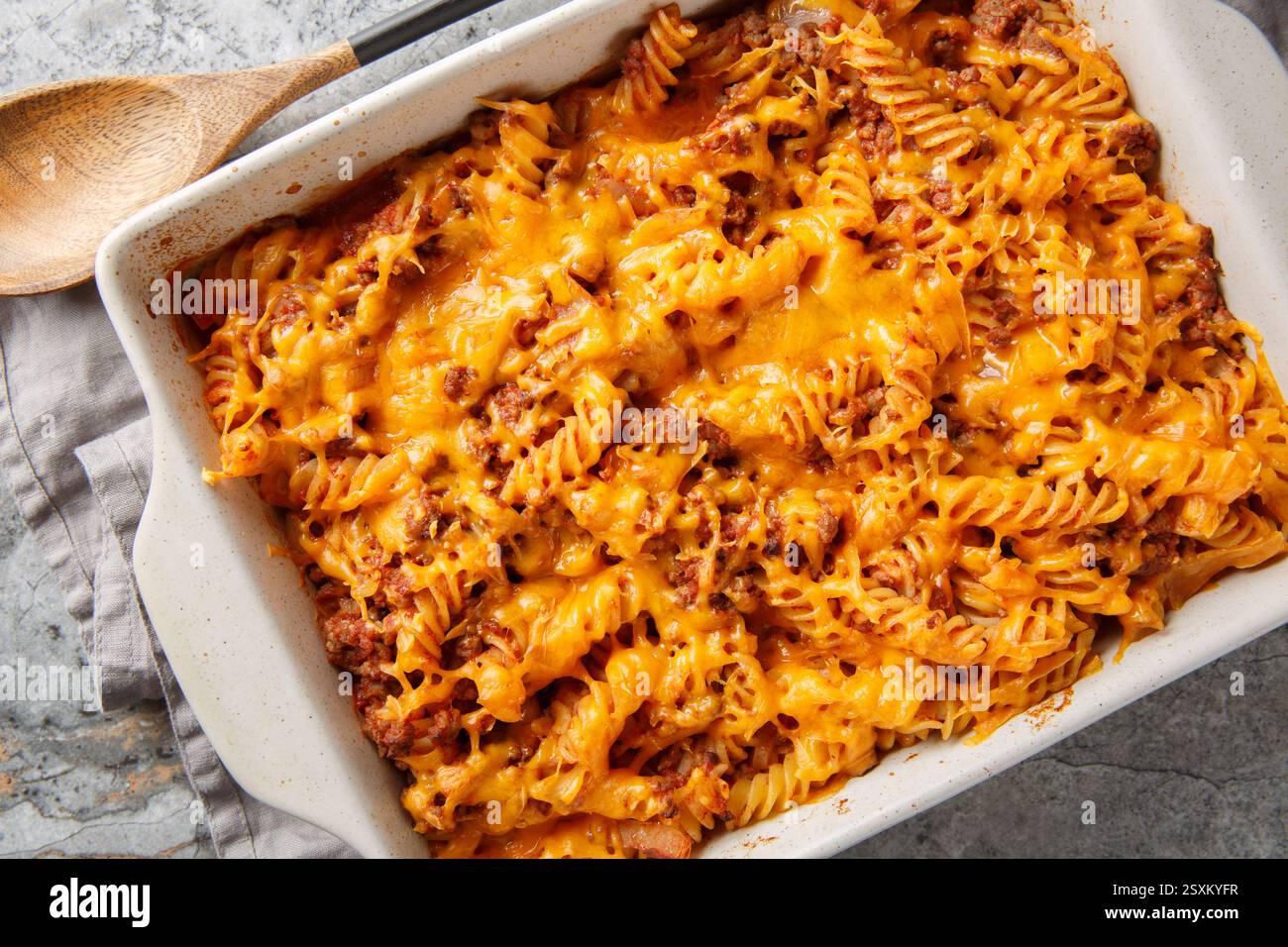 La migliore casseruola Sloppy joe è fatta con carne di manzo macinata, pasta fusilli, verdure e al forno con un sacco di formaggio gooey primo piano nel piatto da forno sul tavolo Foto Stock