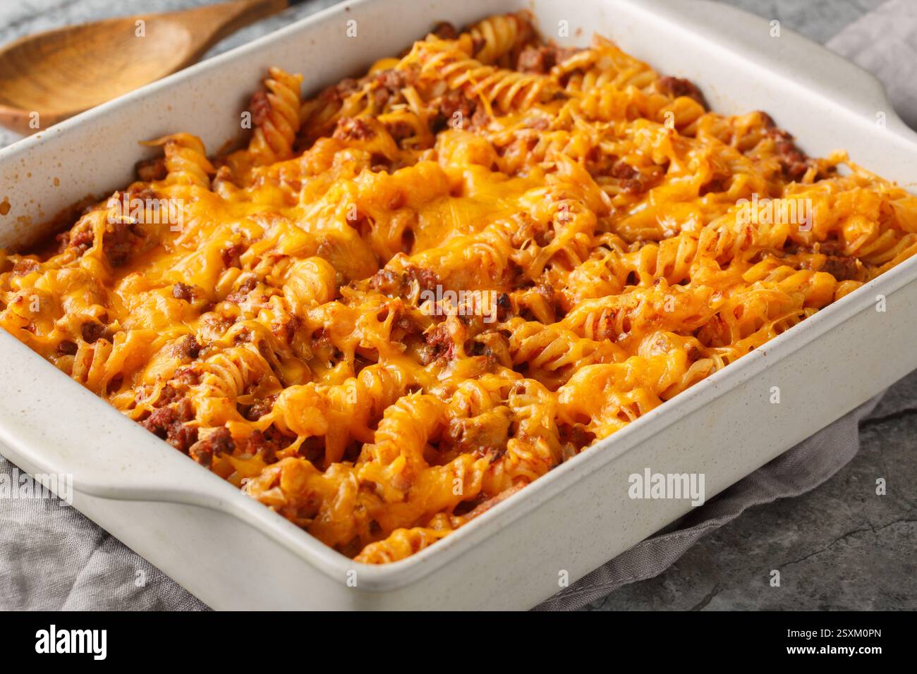 La migliore casseruola Sloppy joe è fatta con carne di manzo macinata, pasta fusilli, verdure e al forno con un sacco di formaggio gooey primo piano nel piatto da forno sul tavolo Foto Stock