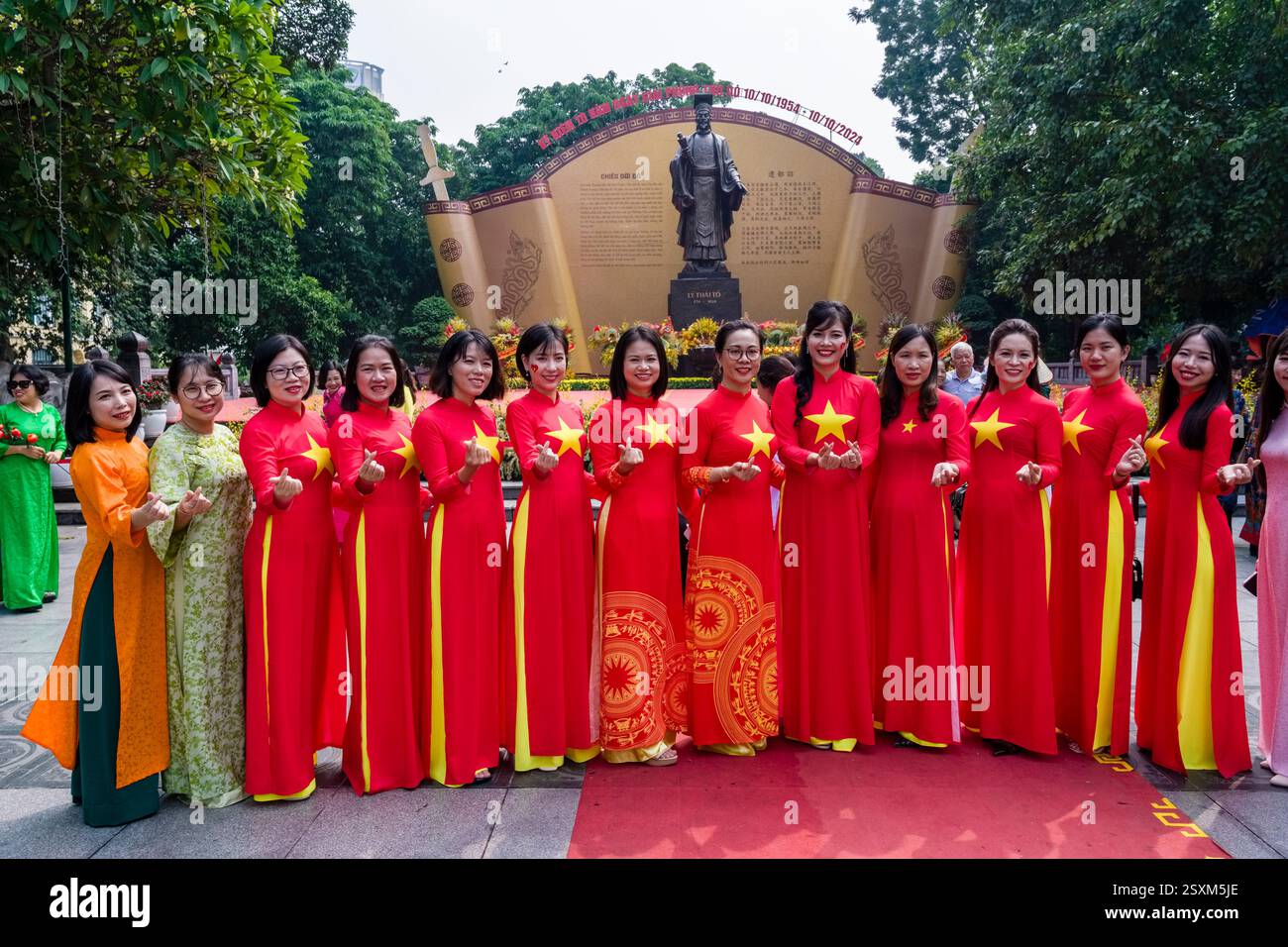 Un gruppo di donne in abiti rossi celebra il 70° anniversario della liberazione della capitale il 10 ottobre 2024. Foto Stock