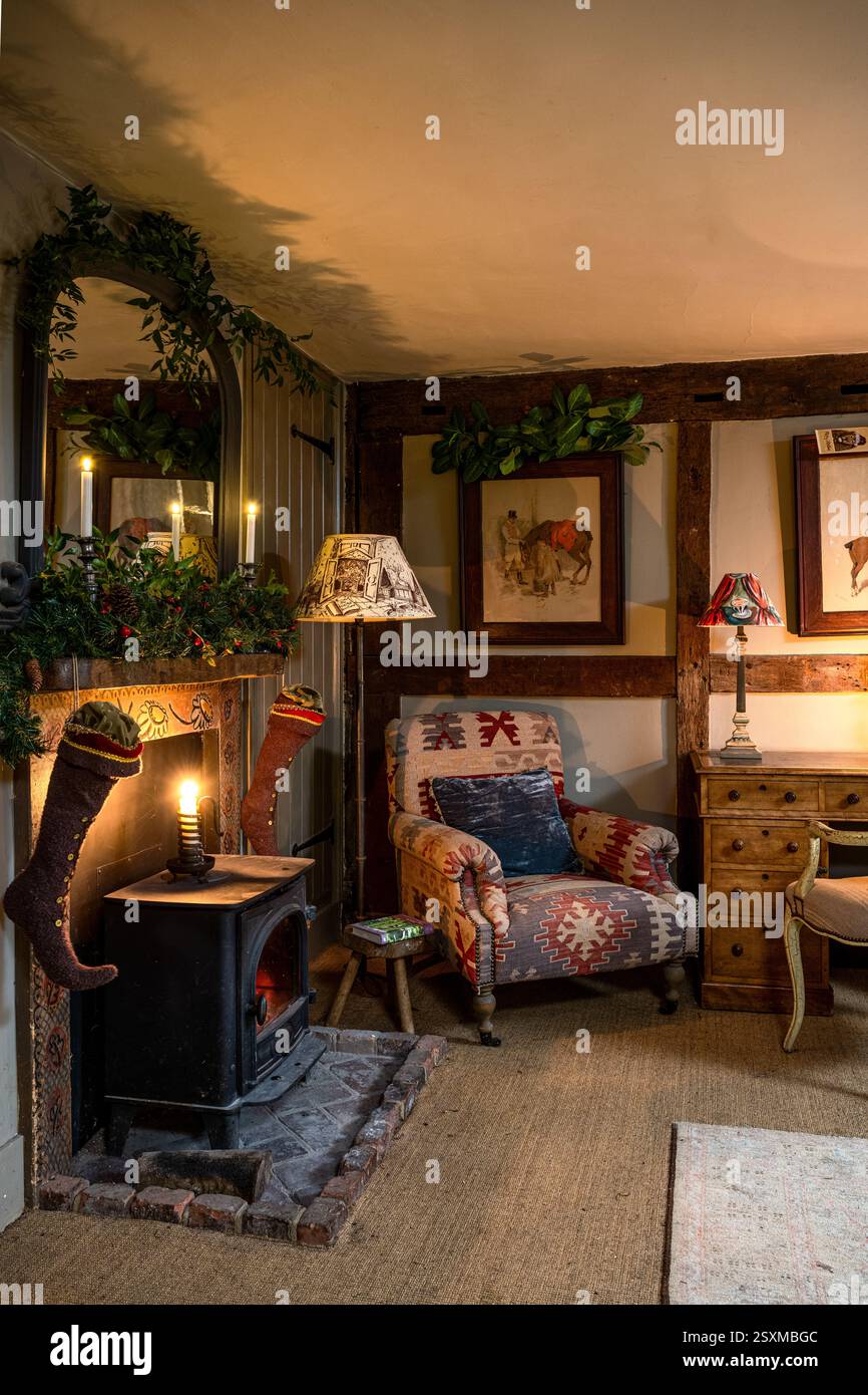 Calze natalizie e stufa a legna in una fattoria ristrutturata dell'East Sussex Tudor risalente al 1540, Inghilterra, Regno Unito. Foto Stock
