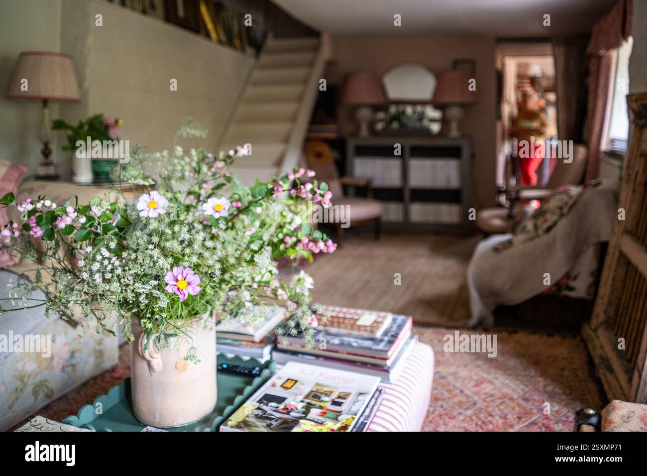 Fiori selvatici su ottomana con scala aperta nel cottage Chalford Weavers nel Cotswolds, Gloucestershire, Inghilterra, Regno Unito. Foto Stock