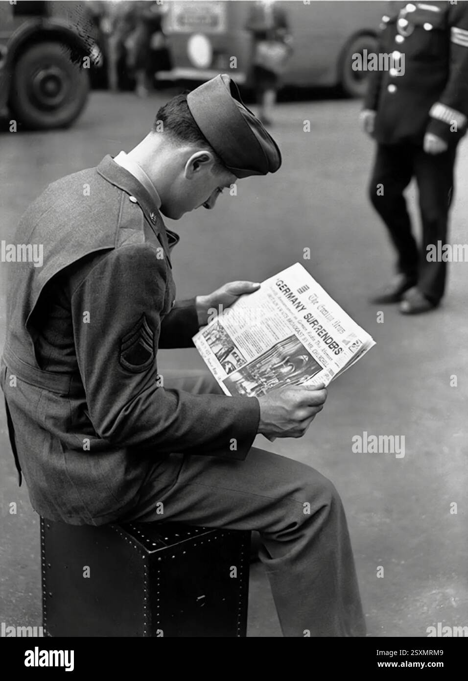Un soldato americano che leggeva il The Evening Times dopo la resa incondizionata delle rimanenti forze armate tedesche agli Alleati, ponendo fine alla seconda guerra mondiale in Europa l'8 maggio 1945. Foto Stock