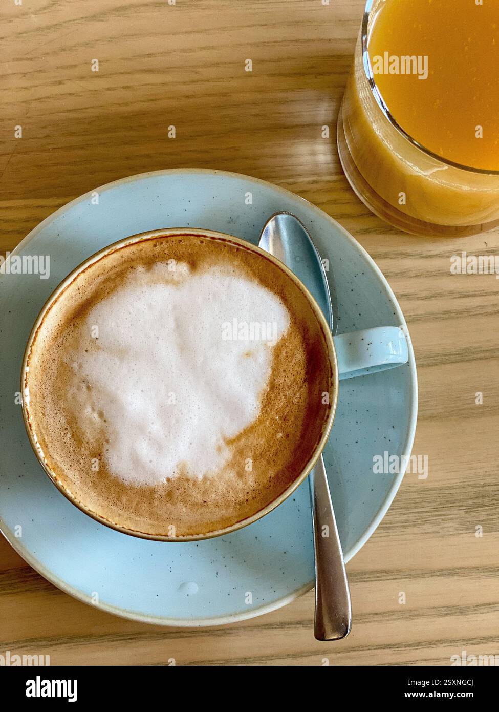 Cappuccino e succo fresco su un tavolo di legno Foto Stock