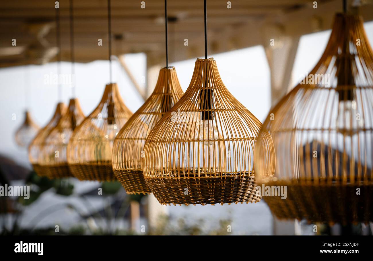Lampade in vimini appese in un ristorante sulla spiaggia. Foto Stock