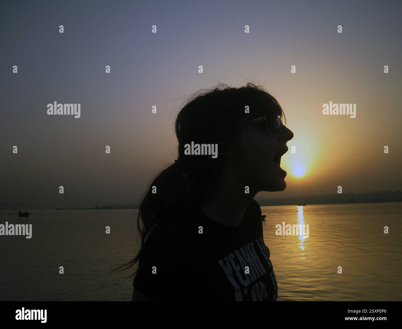 Un grido sagomato contro il tramonto del sole in India da parte di questa studentessa inglese in un tour intorno al mondo prima di iniziare all'università. Foto Stock