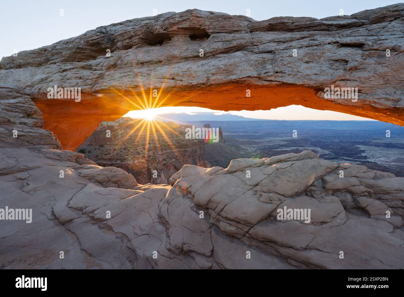 L'alba risplende attraverso Mesa Arch, Canyonlands National Park, Utah Foto Stock