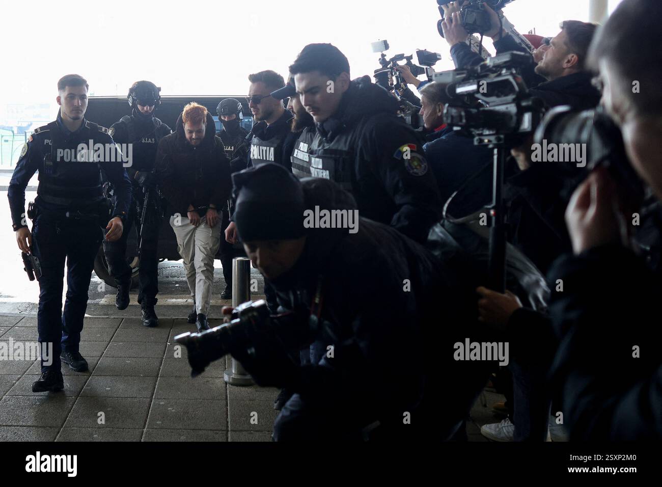 Bucarest, Romania. 25 febbraio 2025. Mohamed Amra è scortato da agenti di polizia sull'aereo che lo trasporterà in Francia, all'aeroporto di Bucarest, Otopeni, Romania, il 25 febbraio 2025. Amra era in fuga da quando è stata liberata nel maggio 2024 in un'imboscata che ha lasciato due agenti di prigione morti. La polizia francese ha arrestato 10 persone sospettate di aiutare il condannato, un procuratore ha dichiarato il 23 febbraio. Foto di Octav Ganea/Inquam Photos/ABACAPRESS. COM credito: Abaca Press/Alamy Live News Foto Stock