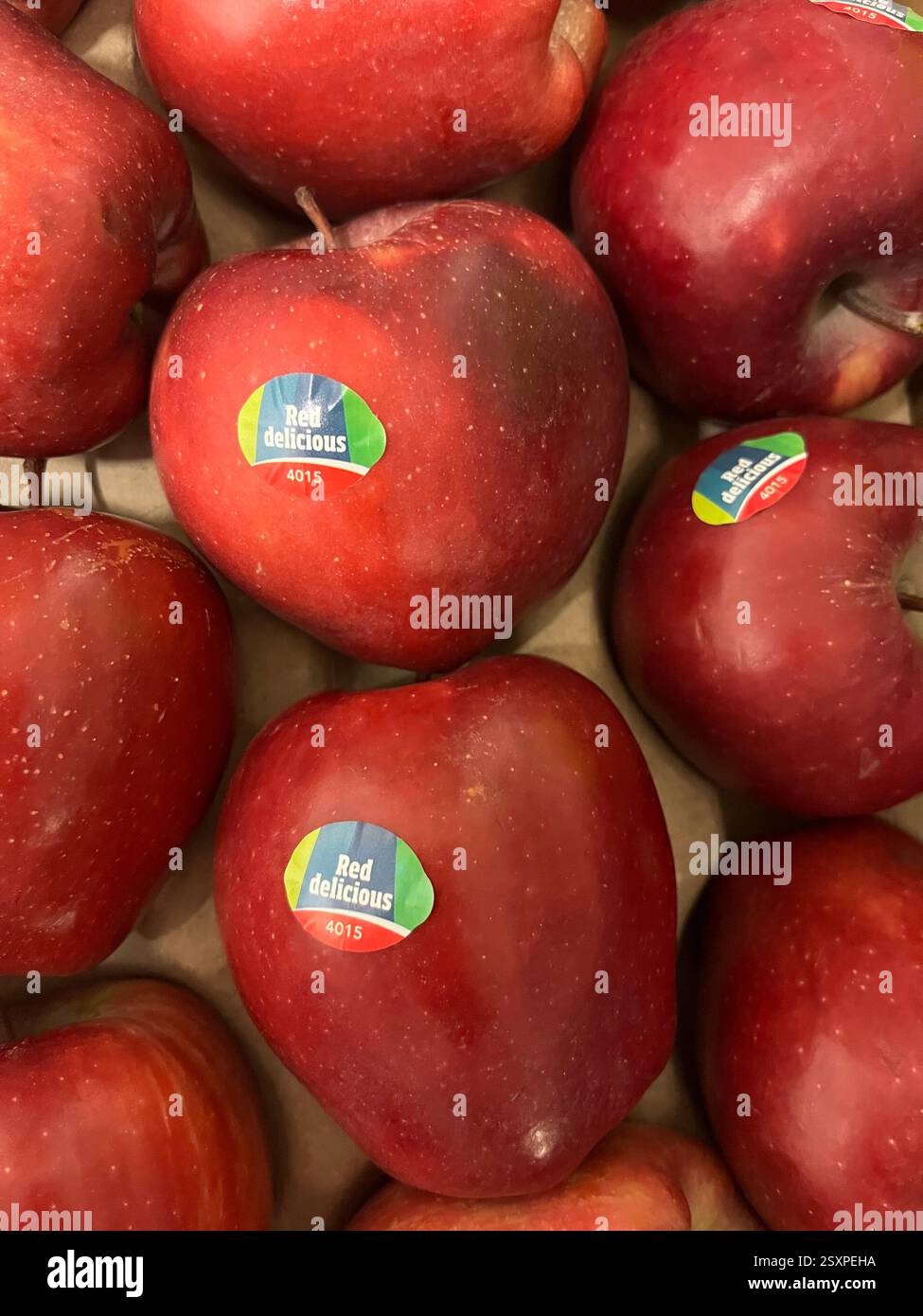 Mele rosse con adesivi "Red Delicious 4015" in esposizione, pronte per la vendita al dettaglio, mele premium, varietà di mele 4015, identificazione delle mele Foto Stock