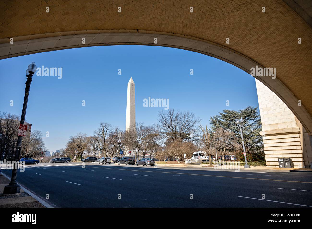 WASHINGTON DC - il Washington Monument si trova all'interno del Wilson Memorial Arch presso il quartier generale del Dipartimento dell'Agricoltura degli Stati Uniti lungo Independence Avenue SW. Questo arco classico di Beaux-Arts commemora James Wilson, che fu Segretario dell'Agricoltura dal 1897 al 1913 sotto i presidenti McKinley, Roosevelt e Taft. La cornice architettonica crea una prospettiva drammatica dell'iconico obelisco attraverso la pietra formale dell'edificio federale. Foto Stock