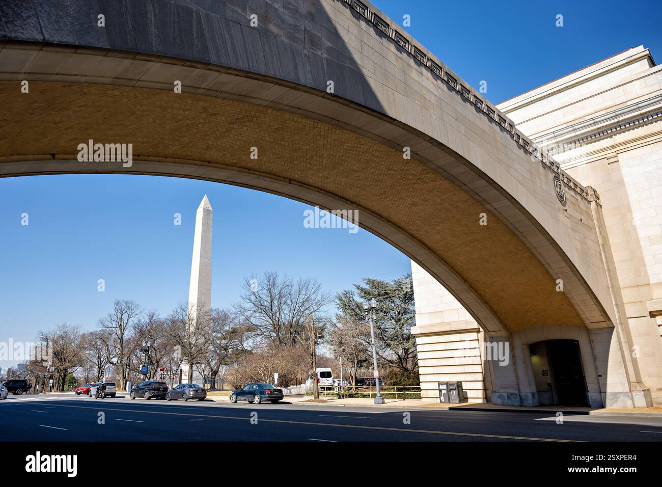 WASHINGTON DC - il Washington Monument si trova all'interno del Wilson Memorial Arch presso il quartier generale del Dipartimento dell'Agricoltura degli Stati Uniti lungo Independence Avenue SW. Questo arco classico di Beaux-Arts commemora James Wilson, che fu Segretario dell'Agricoltura dal 1897 al 1913 sotto i presidenti McKinley, Roosevelt e Taft. La cornice architettonica crea una prospettiva drammatica dell'iconico obelisco attraverso la pietra formale dell'edificio federale. Foto Stock