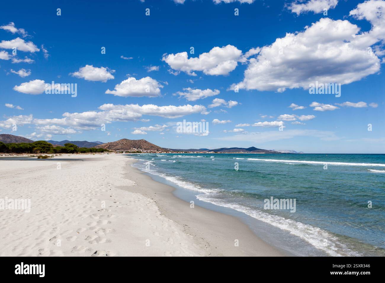 Spiaggia in Sardegna, Italia. Spiaggia sabbiosa di mare Mediterraneo tra Santa Lucia e la Caletta con nuvole bianche sul cielo blu. Foto Stock