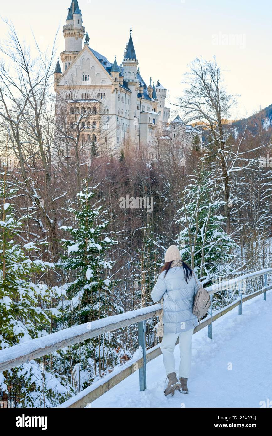 Questa accattivante immagine incarna lo spirito del romanticismo tedesco, con una donna solitaria che cammina attraverso un paesaggio innevato con l'iconico Neus Foto Stock