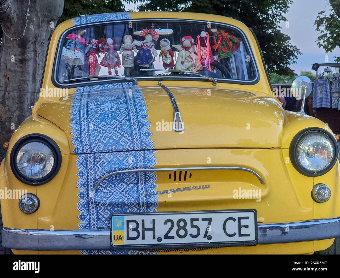 Ucraino sovietico ZAZ Zaporozhets auto in tradizionale ucraino giallo / blu livrea iho 30 ° anniversario dell'indipendenza Ucraina; ZAZ-965; bambole finestra - Immagine stock catturata con smartphone