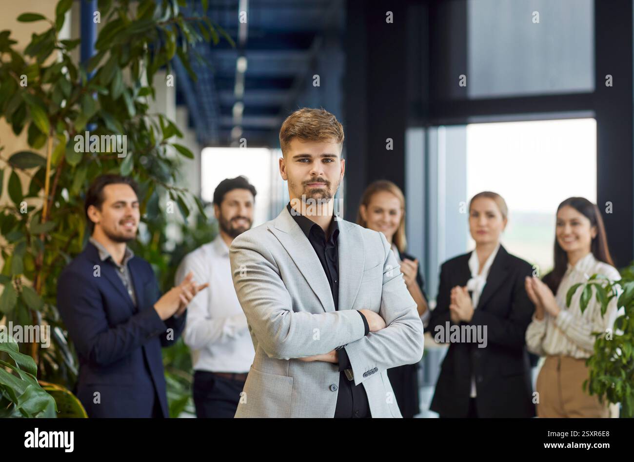 Ritratto di un uomo d'affari serio con Office Team sullo sfondo Foto Stock