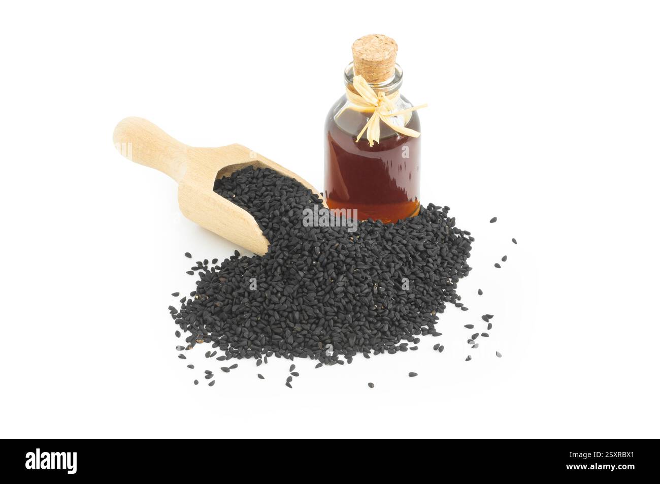Bottiglia in vetro di olio essenziale di semi di cumino nero , Nigella Sativa in cucchiaio isolato su fondo bianco Foto Stock