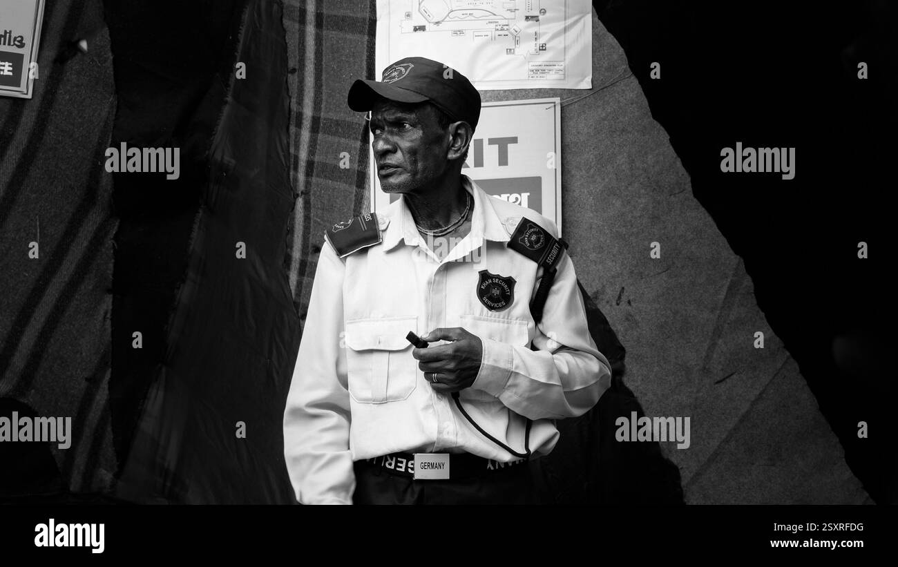 In piedi, a guardare, il suo dovere non dorme mai. La vigilanza di una guardia di sicurezza non è solo vista; è sentita. Foto Stock