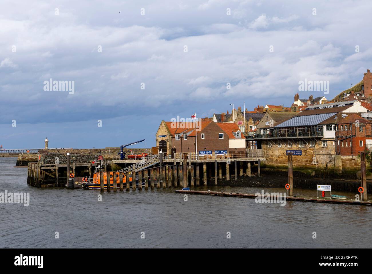 Vista di Whitbys East Cliff che si affaccia sul porto storico e sull'abbazia di cottage e case Foto Stock