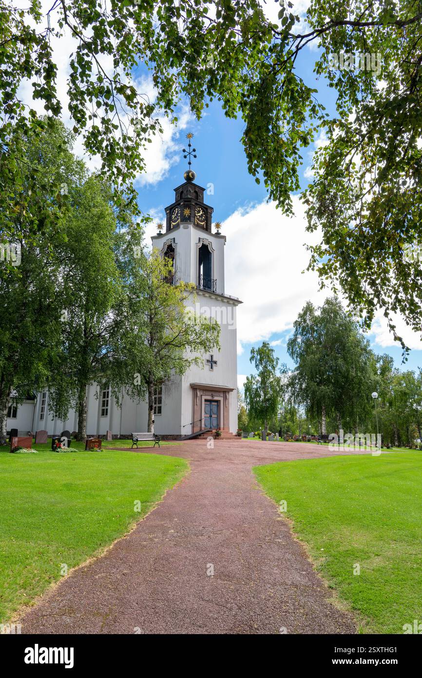 Una giornata tranquilla nella Chiesa di Svezia a Idre Dalarna, tra alberi verdi sotto un cielo blu e nuvole bianche. I visitatori apprezzano l'atmosfera tranquilla Foto Stock