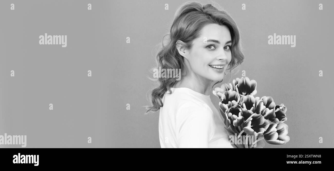 ragazza felice con bouquet di tulipani su sfondo blu. giornata delle donne. Donna isolato volto ritratto, banner con mock su copyspace. Foto Stock