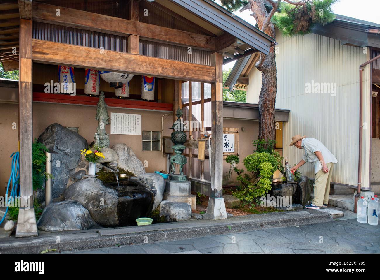 Un uomo raccoglie l'acqua in una delle sorgenti lungo il fiume Itachi nella città di Toyoma, prefettura di Toyama, Giappone, il 13 settembre 2017 Foto Stock