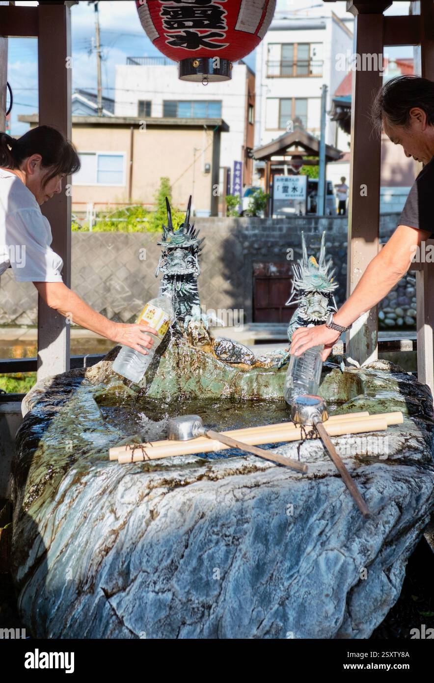 I residenti raccolgono l'acqua sorgiva in una delle sorgenti lungo il fiume Itachi nella città di Toyoma, prefettura di Toyama, Giappone il 13 settembre 2017. Foto Stock