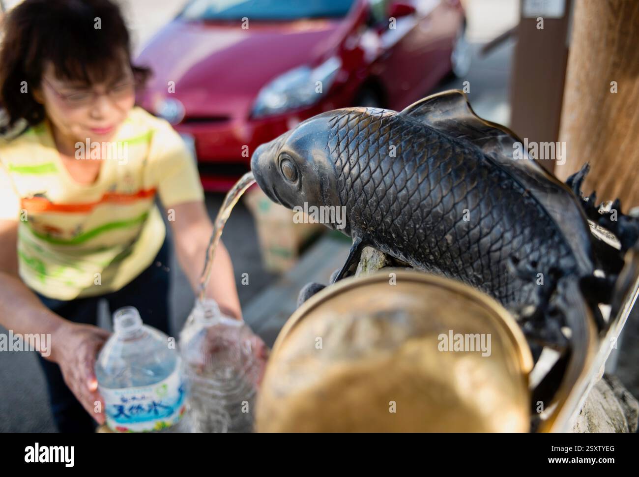 I residenti raccolgono l'acqua sorgiva presso la sorgente decorativa lungo il fiume Itachi nella città di Toyoma, prefettura di Toyama, Giappone il 13 settembre 2017. ROBERT GILHOOLY Foto Stock