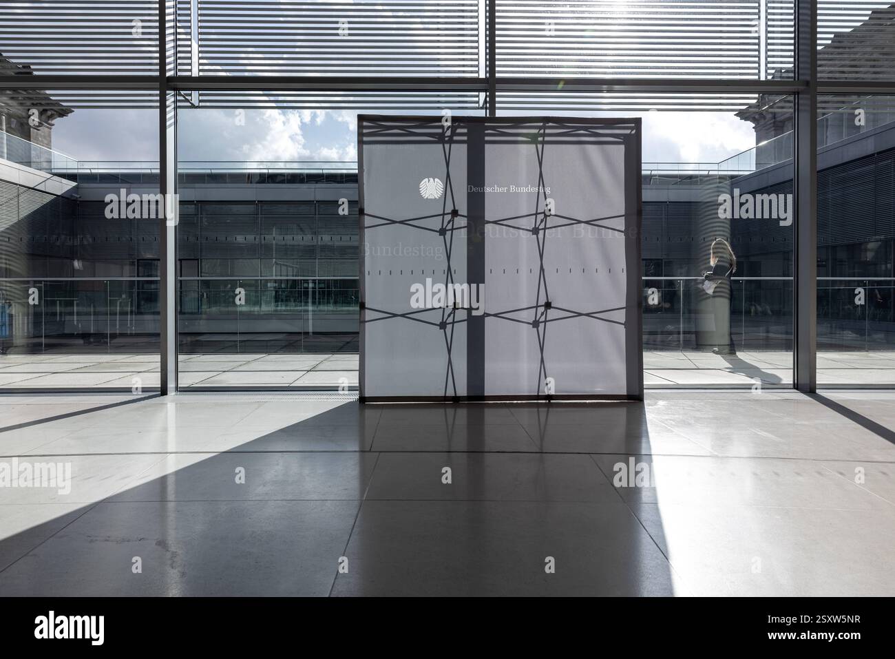 Bundestagsaufsteller auf der Fraktionsebene im Bundestag. Deutschland Berlin AM 25.02.2025: Ein grauer Aufsteller im Bundestag, der als Hintergrund für intervista Dient, Wird von der Sonne von hinten beleuchtet. Man sieht die silhouette des Gerüsts. *** Bundestag stand-up display a livello di gruppo parlamentare nel Bundestag Germania Berlino al 25 02 2025 Un stand-up grigio nel Bundestag, che funge da sfondo per interviste, è illuminato dal sole da dietro la sagoma dell'impalcatura Foto Stock