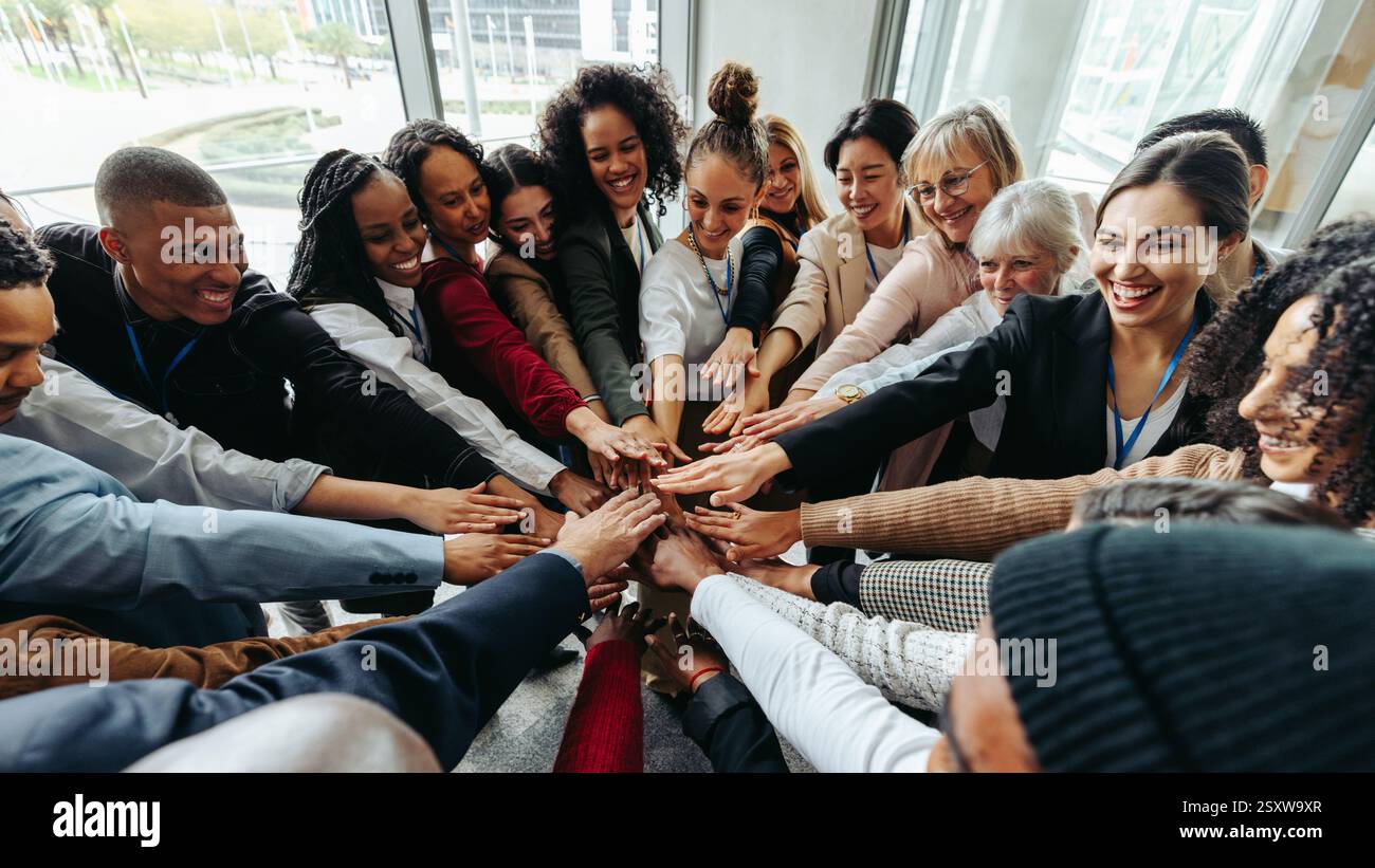 Team di successo che lavorano insieme mostrando unità e collaborazione in un ambiente d'ufficio con background diversi. Foto Stock