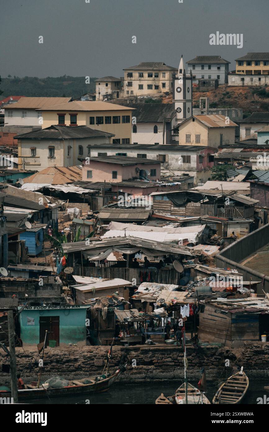 Il panorama verticale di Elmina, città storica dell'Africa occidentale, con chiese e case residenziali. Foto Stock