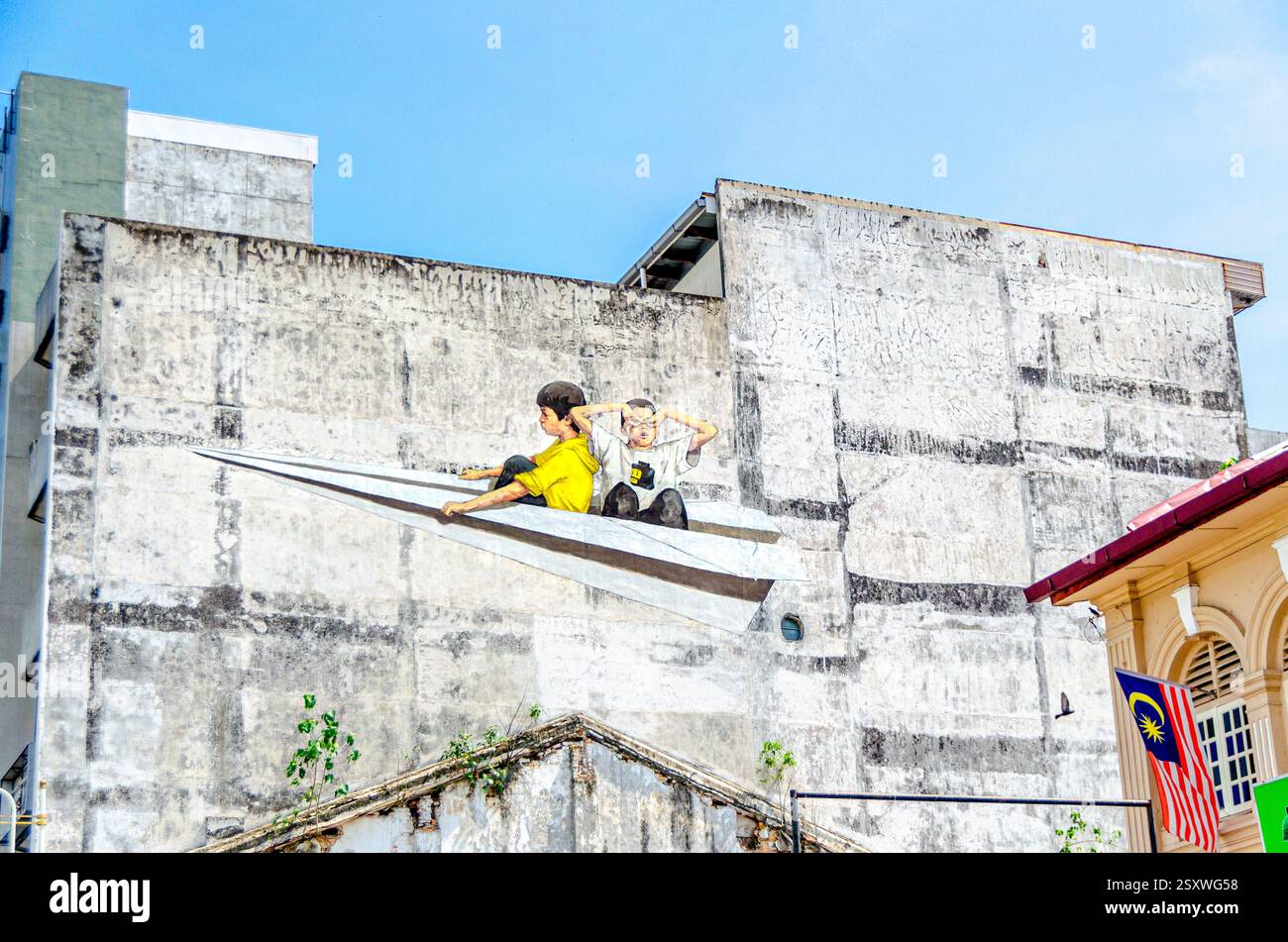 Piano di carta - Street Art raffigurante bambini su un aereo di carta contro un muro di cemento Foto Stock