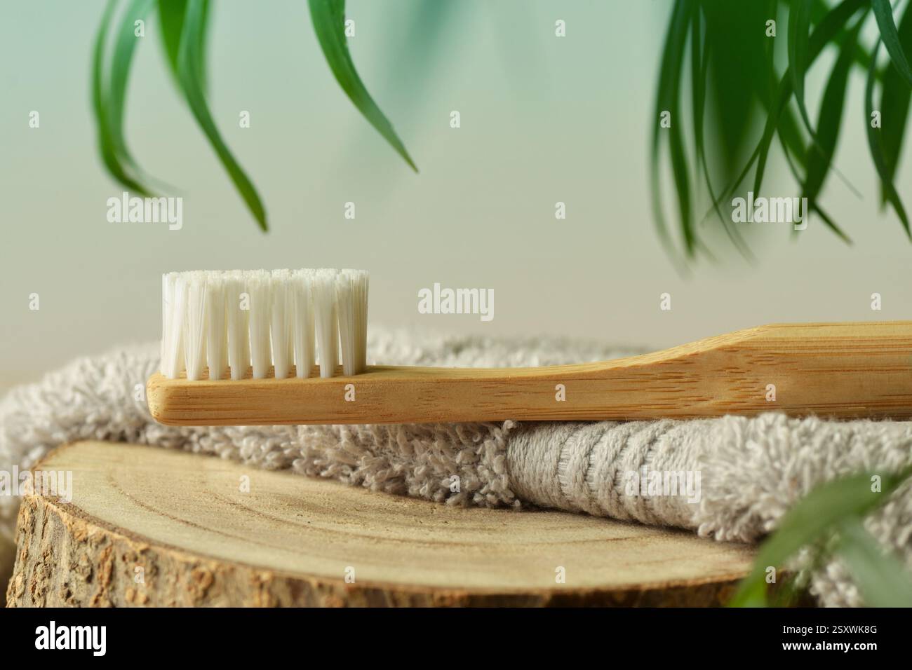 Spazzolino da denti in legno su asciugamano con sfondo naturale - concetto di ecologia e prodotti naturali Foto Stock