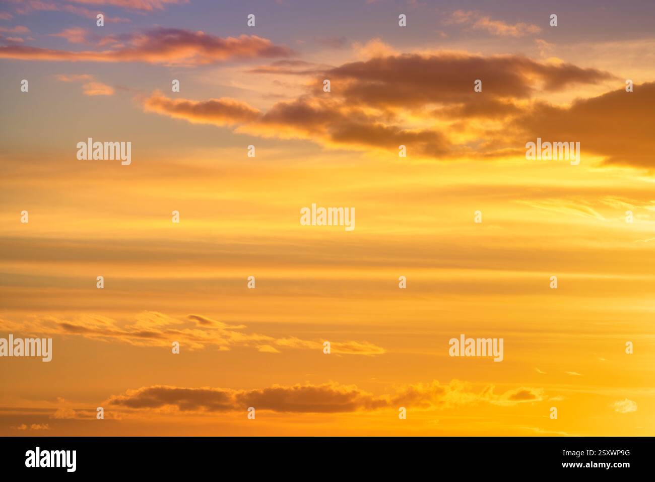 Spettacolari nuvole rosse, arancioni e gialle in un vero cielo ardente al tramonto. Fotografia ad alta risoluzione per la sostituzione del cielo, lo sfondo o la progettazione grafica Foto Stock