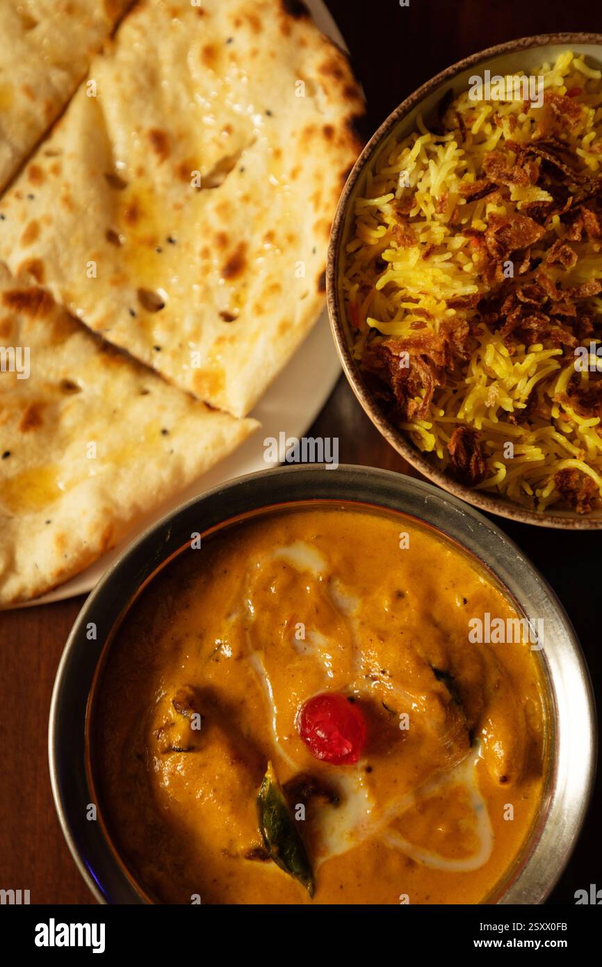 Deliziosa cucina indiana con pollo al burro, Naan e riso Biryani aromatizzato Foto Stock