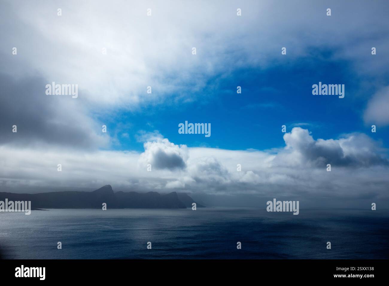 Mare con montagne in lontananza Foto Stock