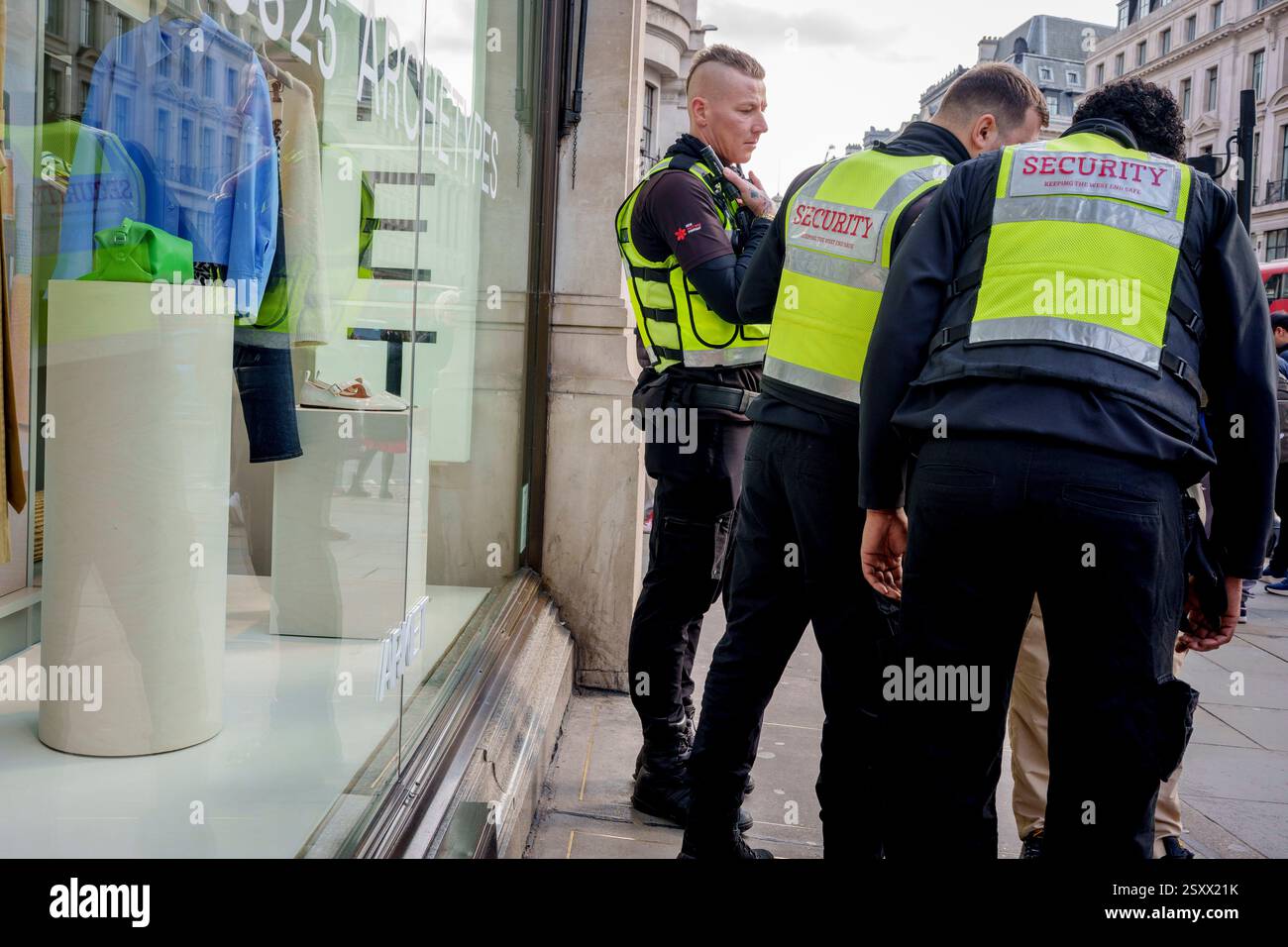 Tre guardie di sicurezza fanno una presenza contro la vendita al dettaglio e la criminalità personale, fuori da un negozio in Regent Street, il 25 febbraio 2025, a Londra, Inghilterra. Il taccheggio ha registrato un triplice aumento delle intercettazioni e delle rapine in tutto il West End, con turisti e rivenditori ricchi sempre più afflitti da criminali. Foto Stock