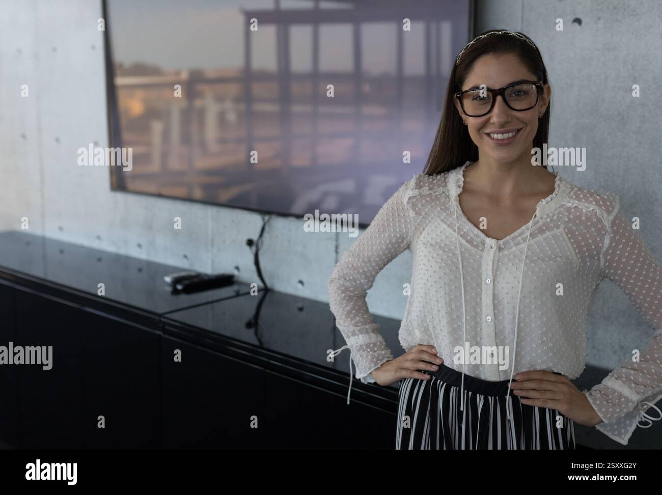 Donna sorridente che indossa gli occhiali in un moderno ambiente d'ufficio, si sente sicura, copia spazio Foto Stock