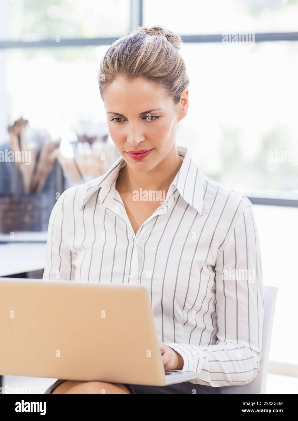 Donna professionale che lavora con un notebook a casa, concentrata e produttiva Foto Stock