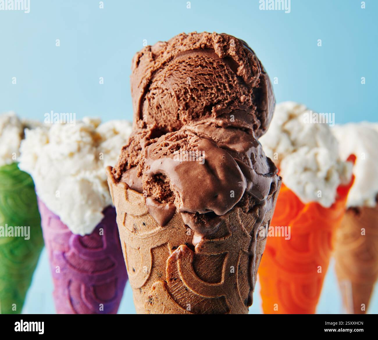 Gelato al cioccolato con cospargimenti in coni di diversi colori Foto Stock
