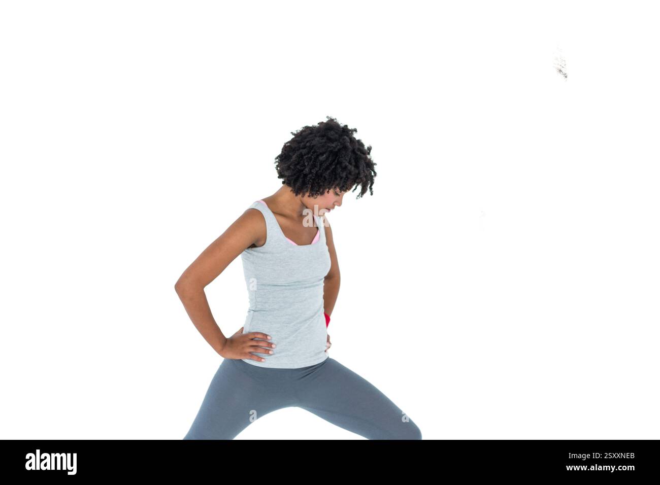 Donna che si allunga con gli outfit per l'allenamento, concentrandosi sul fitness e sulla flessibilità Foto Stock