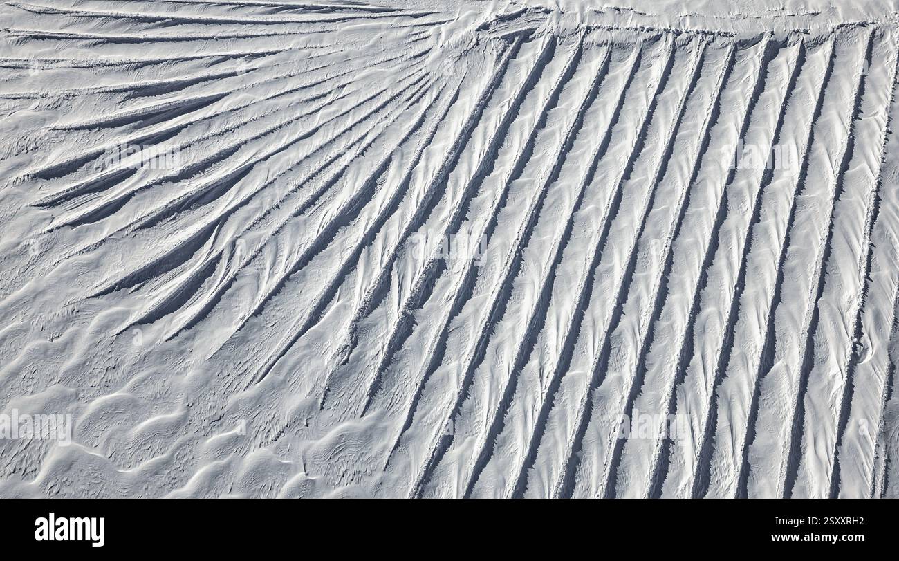 Una vista aerea delle intricate formazioni di neve sul Ghiacciaio 3000 nelle Alpi svizzere. Il vento ha scolpito la neve in un ipnotico schema di r Foto Stock