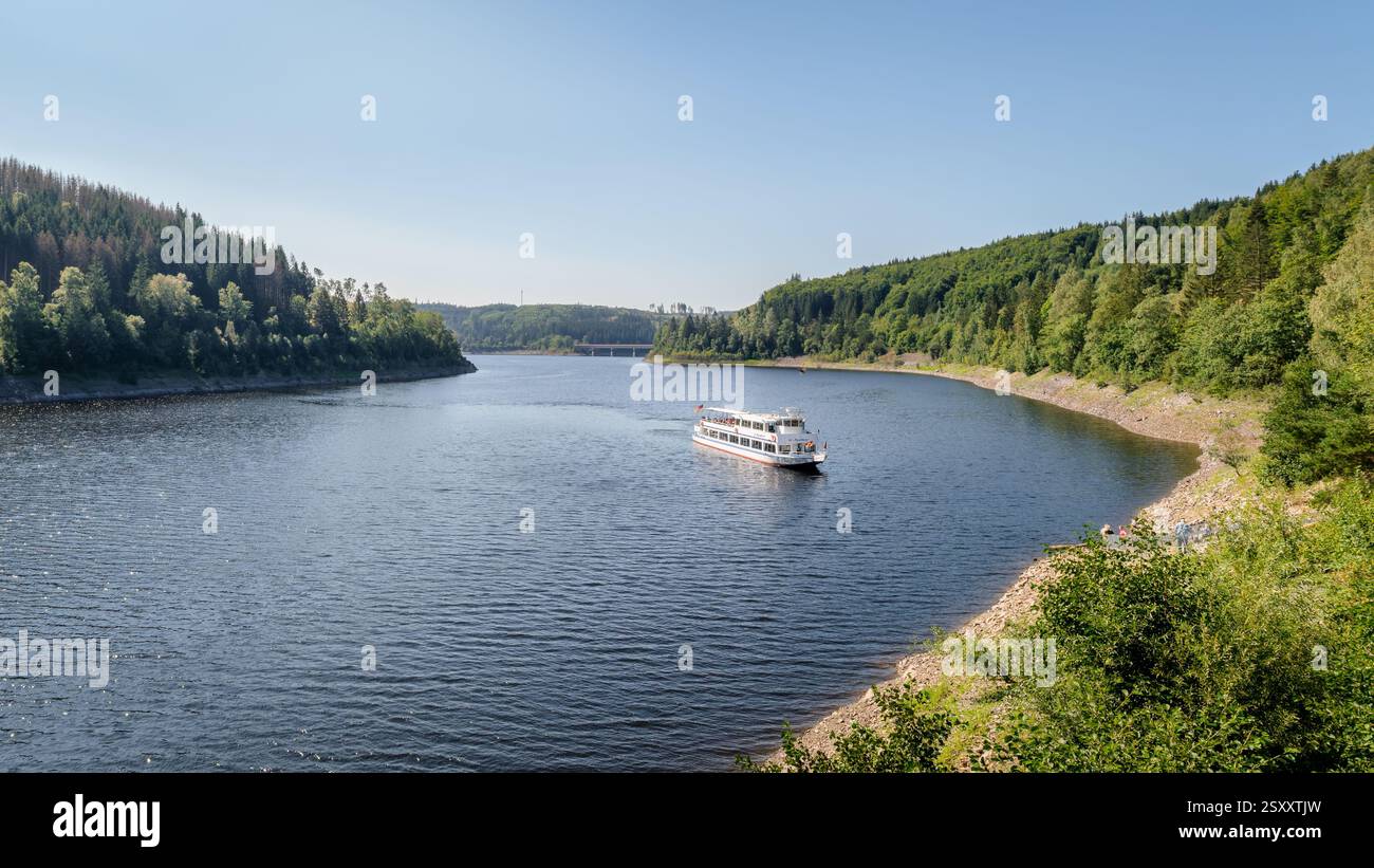 Diga di Oker, Germania - 28 agosto 2024: Un tour in barca naviga sopra il bacino idrico di Oker. La diga di Oker è una diga nei bassifondi di Harz alimentata dal fiume Oker. Foto Stock
