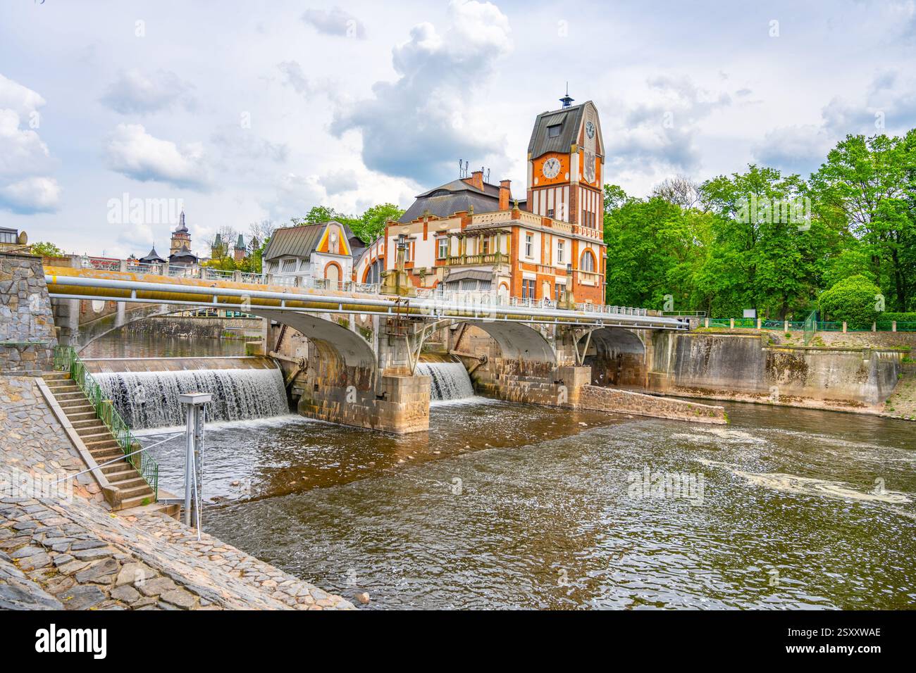 Lo splendido edificio in stile Art Nouveau della centrale idroelettrica di Hucak abbellisce le rive del fiume a Hradec Kralove, mostrando un design intricato e una natura vibrante nel paesaggio circostante. Foto Stock