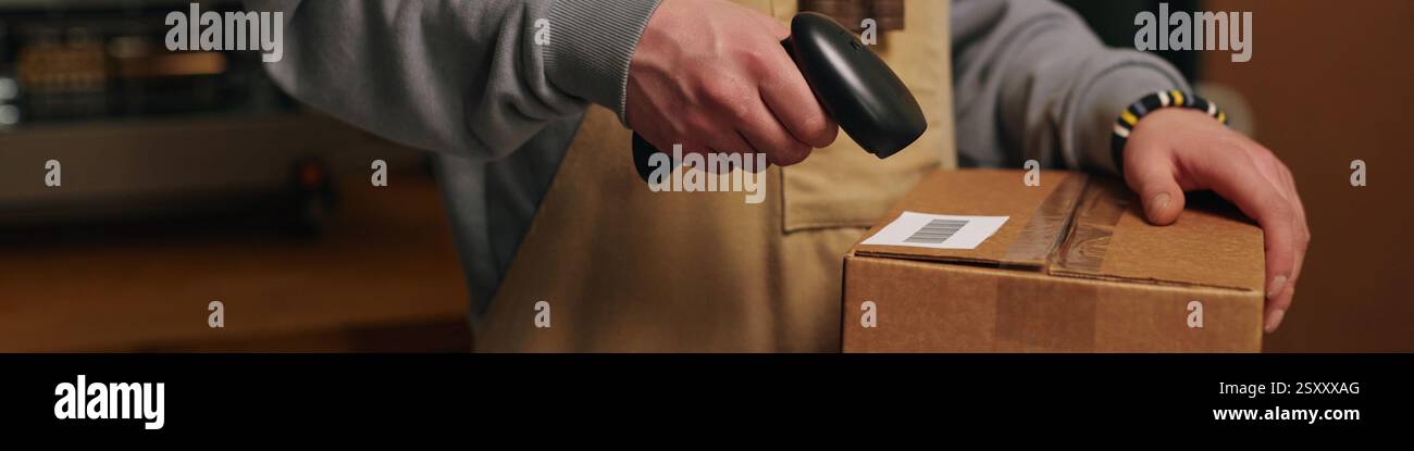Banner del sito Web con primo piano medio di un uomo irriconoscibile che esegue la scansione del codice a barre su una scatola di cartone Foto Stock